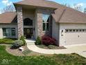 Close-up of a brick home's entrance with a three car garage and mature landscaping at 8188 Spring Valley Dr, Plainfield, IN 46168