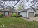 Inviting home with brick and grey siding, featuring a two-car garage and landscaped front yard at 9118 Lansburgh Ct, Indianapolis, IN 46234