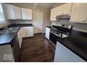 Modern kitchen featuring white cabinets, stainless steel appliances, and dark countertops at 9118 Lansburgh Ct, Indianapolis, IN 46234