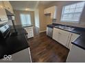 Well-lit kitchen with white cabinetry, stainless steel appliances, and dark countertops at 9118 Lansburgh Ct, Indianapolis, IN 46234