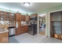Well-lit kitchen featuring stainless steel appliances, wooden cabinetry, and stylish backsplash at 1021 N Bolton Ave, Indianapolis, IN 46219