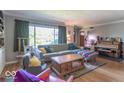 Bright living room boasting hardwood floors, large window, and comfortable seating arrangement at 1021 N Bolton Ave, Indianapolis, IN 46219