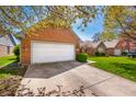 Brick home with a two-car garage, manicured lawn, and lush landscaping, offering classic curb appeal at 1127 Alydar Cir, Indianapolis, IN 46217