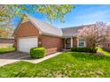 Inviting single-story brick home with manicured front lawn, mature landscaping, and an attached two-car garage at 1127 Alydar Cir, Indianapolis, IN 46217