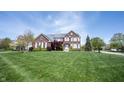 Classic brick home with a well-maintained lawn and mature trees in a suburban setting at 11592 Saltford Ln, Fishers, IN 46037
