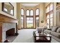 Bright living room boasts fireplace, large windows with scenic view, and stylish furniture at 12010 Landover Ln, Fishers, IN 46037