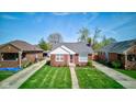 An aerial view of a well maintained home with mature trees, and a lush green lawn in a residential neighborhood at 1209 N Downey Ave, Indianapolis, IN 46219