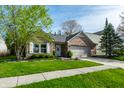 Charming brick home with a well-manicured lawn, mature trees, and an attached two-car garage at 12210 Doncaster Ct, Fishers, IN 46037