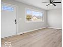Bright living room with light-colored walls, new vinyl floors, ceiling fan, and ample natural light at 1243 N Post Rd, Indianapolis, IN 46219