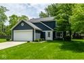 Charming two-story home featuring navy siding, white trim, an attached two-car garage, and a well-manicured lawn at 12577 Pointer Pl, Fishers, IN 46038
