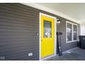 Bright yellow front door with glass, set against gray siding and white trim at 1835 N Rural St, Indianapolis, IN 46218