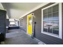Covered front porch featuring a bright yellow door and well-lit entry at 1835 N Rural St, Indianapolis, IN 46218