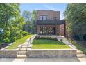 Inviting brick two-story home with a covered front porch, complemented by a lush, manicured lawn at 1907 N Alabama St, Indianapolis, IN 46202