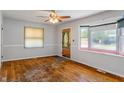 A spacious living room with a large window, hardwood floors, and a ceiling fan at 219 S Sherman Dr, Indianapolis, IN 46201