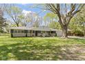 Charming single-story home featuring a brick and stone facade, well-manicured lawn and large shade tree at 2325 Melody Ln, Anderson, IN 46012