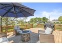 Inviting backyard deck with outdoor seating, a fire pit, and a grill, ideal for relaxing and entertaining at 3582 Fieldhurst Ln, Plainfield, IN 46168