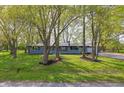 Beautifully landscaped front yard with mature trees and a view of the gray brick home at 4450 Bridgefield West Dr, Plainfield, IN 46168
