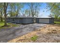 Home exterior featuring a gray brick facade, detached garage and a spacious driveway at 4450 Bridgefield West Dr, Plainfield, IN 46168