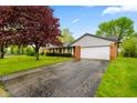 Traditional brick home with attached garage, green lawn, and paved driveway on a sunny day at 507 S Grant St, Brownsburg, IN 46112