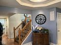 Inviting entryway with wooden staircase, accent table, large clock, and decorative wall art at 5640 Dapple Ct, Indianapolis, IN 46228