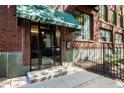 Building entrance with awning and brick facade, modern glass doors, and black iron fence detail at 624 E Walnut St # 46, Indianapolis, IN 46204