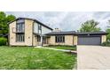 Charming stone house with lush front lawn, two-car garage, and well-maintained landscaping at 660 Sun Valley Ct, Indianapolis, IN 46217