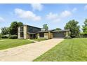 Charming stone and siding home with well-maintained lawn and long driveway leading to the garage at 660 Sun Valley Ct, Indianapolis, IN 46217