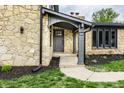 Close-up shot of stone house entrance, showcasing covered porch with walkway leading to the front door at 660 Sun Valley Ct, Indianapolis, IN 46217
