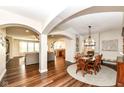 Open dining area with wood table, chairs, hardwood floors, and elegant lighting at 6625 W Winding Bnd, McCordsville, IN 46055