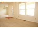 A bright living room features neutral carpeting, large windows, and a white front door with decorative glass at 6725 Tramcus Dr, Indianapolis, IN 46260