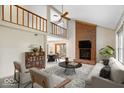 Bright living room features a soaring ceiling, brick fireplace, and seamless flow to dining area at 7424 Prairie Lake Dr, Indianapolis, IN 46256