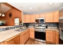 Well-equipped kitchen with stainless steel appliances, tile backsplash, and light wood cabinets at 921 Kimberly Ave, Westfield, IN 46074