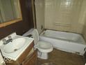 Compact bathroom featuring a standard tub, toilet, and sink with wood-look flooring at 100 N Blue River Dr, Edinburgh, IN 46124