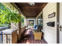 Cozy front porch with seating area, tile flooring, and hanging plants perfect for relaxing outdoors at 1044 E Garfield Dr, Indianapolis, IN 46203
