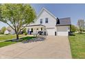 Stunning two-story home with a welcoming front porch, white siding, a well-manicured lawn and spacious driveway at 11124 Winterwood Dr, Indianapolis, IN 46235
