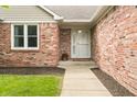 Inviting front entrance featuring red brick, a white trimmed door, and a small pot of flowers at 1170 Runningbrook Dr, Avon, IN 46123