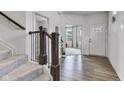 Inviting home entryway with hardwood floors, staircase, and views into the open living area. Natural light pouring in from windows at 15120 Downham Dr, Fishers, IN 46037