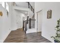 Spacious two-story home entryway with hardwood floors and staircase with iron spindles. Doors leading to multiple rooms in the home at 15120 Downham Dr, Fishers, IN 46037