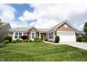 Charming brick home with manicured lawn, lush landscaping, and a two-car garage at 16204 Oakford Trl, Fishers, IN 46037