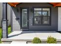Charming front porch featuring sleek black door, window, and stone column accents at 2226 Central Ave, Indianapolis, IN 46205