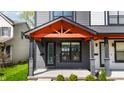 Inviting front porch with stylish entrance featuring an orange gable roof and dark gray siding at 2226 Central Ave, Indianapolis, IN 46205