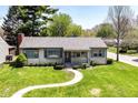 Inviting home with manicured lawn and blue trim offers great curb appeal at 251 S 12Th Ave, Beech Grove, IN 46107