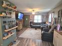 Spacious living room features a large leather sofa, decorative shelves, and wood-paneled accent wall at 2650 Woodrow Ave, Indianapolis, IN 46241