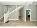 Inviting foyer with wood-look floors, staircase, and neutral gray walls at 344 N Addison St, Indianapolis, IN 46222