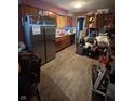 Displays wooden cabinetry, stainless steel refrigerator, and laminated floors, but it is extremely cluttered at 3742 S Walcott St, Indianapolis, IN 46227