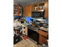 Reveals a stainless steel oven, a microwave, wooden cabinets, and laminated floors but is in need of decluttering at 3742 S Walcott St, Indianapolis, IN 46227