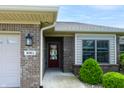 Brick home featuring a covered entrance with a decorative front door and manicured landscaping at 4061 Melbourne Dr, Columbus, IN 47203