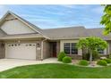 Charming brick home featuring a manicured lawn, attached two car garage, and covered entry way at 4061 Melbourne Dr, Columbus, IN 47203