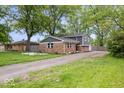 Side view of home's exterior showcasing the brick and siding, lawn, and curb appeal at 5719 Laurel Hall Dr, Indianapolis, IN 46226