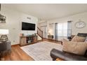 Bright living room boasts hardwood floors, modern decor, and a seamless connection to the entryway and staircase at 6373 Thornridge Dr, Avon, IN 46123